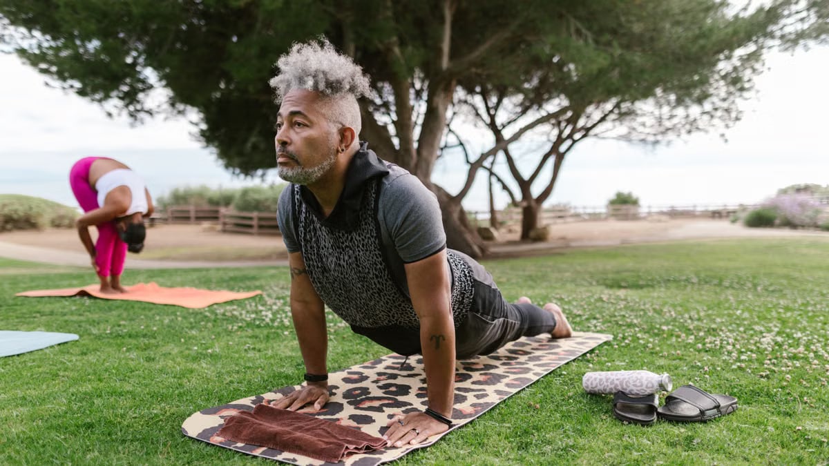 A group practicing yoga in a scenic outdoor park, promoting wellness and relaxation.